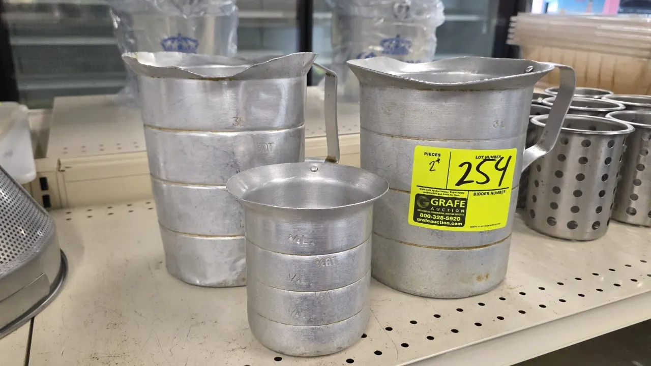 Aluminum graduated water and measuring pitchers. Includes (2) 3L pitchers with pour spouts and (1) 3/4L measuring cup. Features riveted side handles a