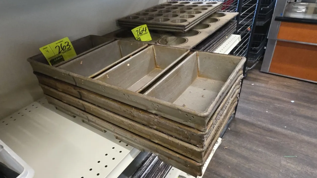 4-loaf strap bread pans. Features commercial metal construction with strapped 4-cavity loaf design. 9" x 22".