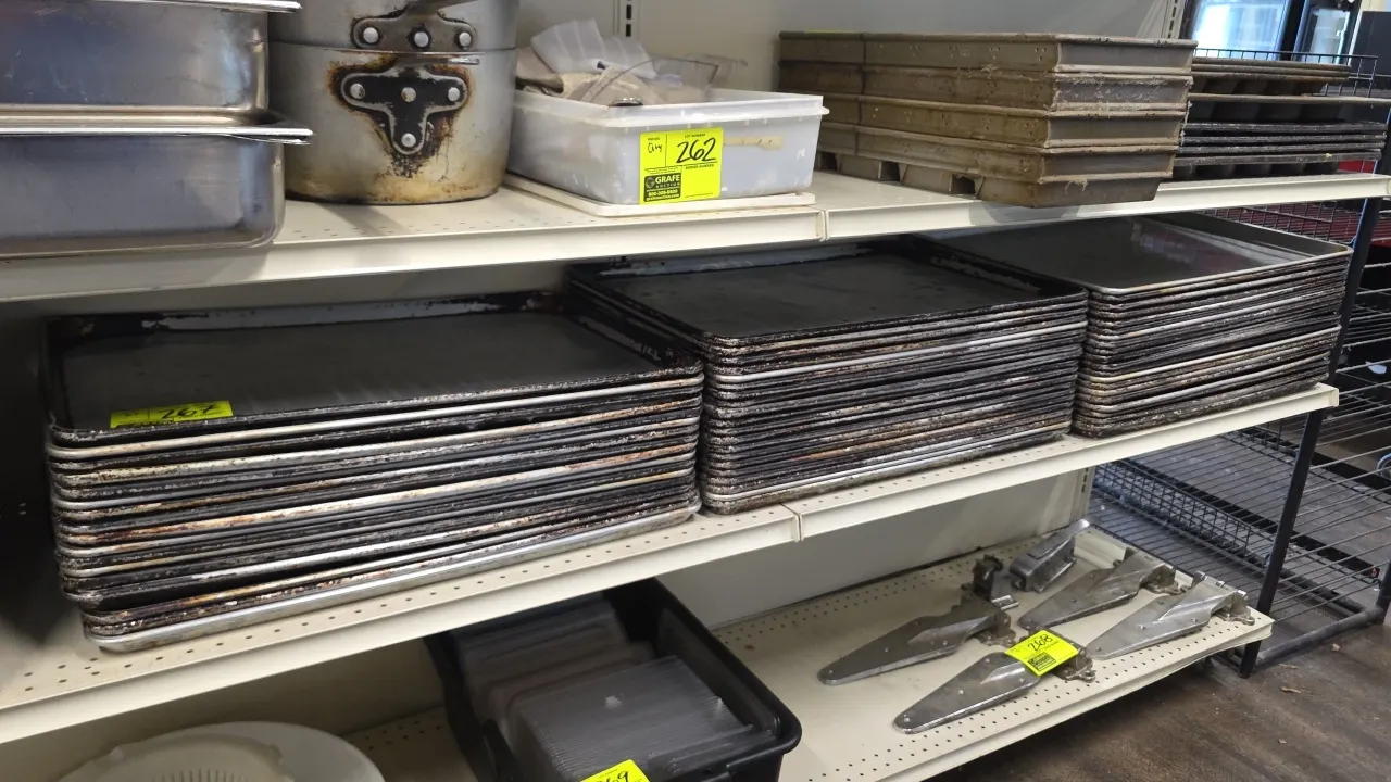 Full-size aluminum sheet pans. Features rolled edges with wire reinforcement. Shelving and background items not included.
