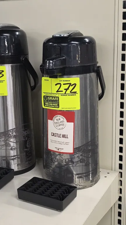 Stainless steel thermal coffee dispenser. Features push-lever dispensing mechanism, top carry handle, and New England Coffee graphic wrap. Includes bl