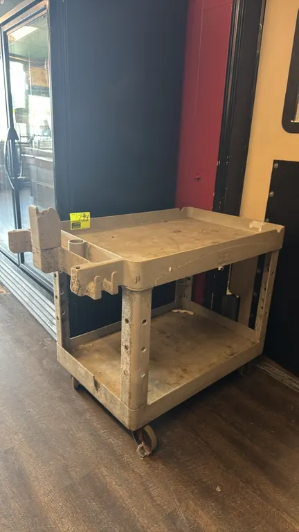 Rubbermaid Commercial Products 2-tier poly utility cart. Features molded-in accessory compartments and lipped shelves. 36" x 24". Mounted on casters.