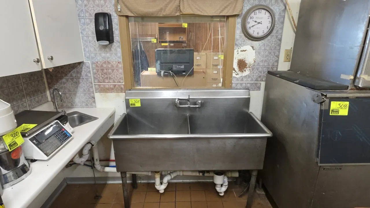Stainless steel 2-compartment sink with integrated backsplash and faucet. 51" x 22" x 34". Mounted on tubular legs. Package includes a wall-mount soap