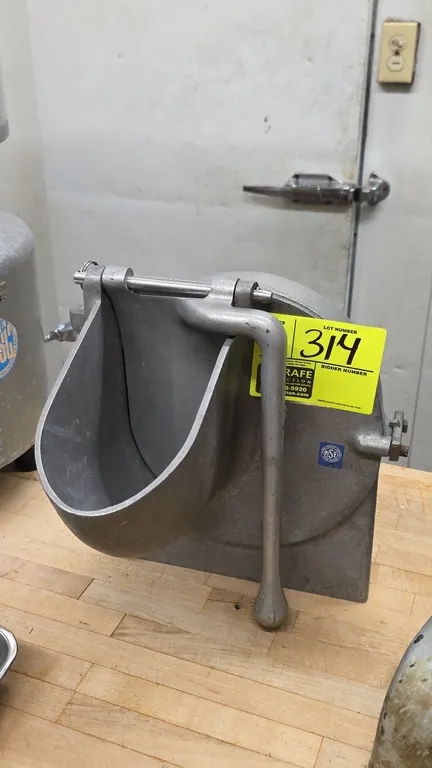 Hobart vegetable slicer and shredder attachment. Features cast aluminum housing, feed hopper with pusher handle, interior slicing disc, and rear hub d
