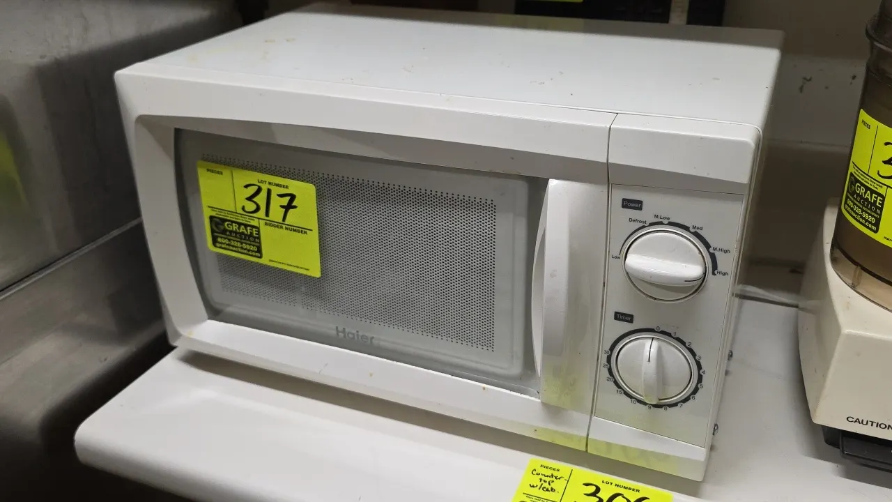 2012 Haier HMC610BEWW countertop microwave oven. Features dual rotary dial controls for power levels and timer, and interior glass turntable. S/N: HMC