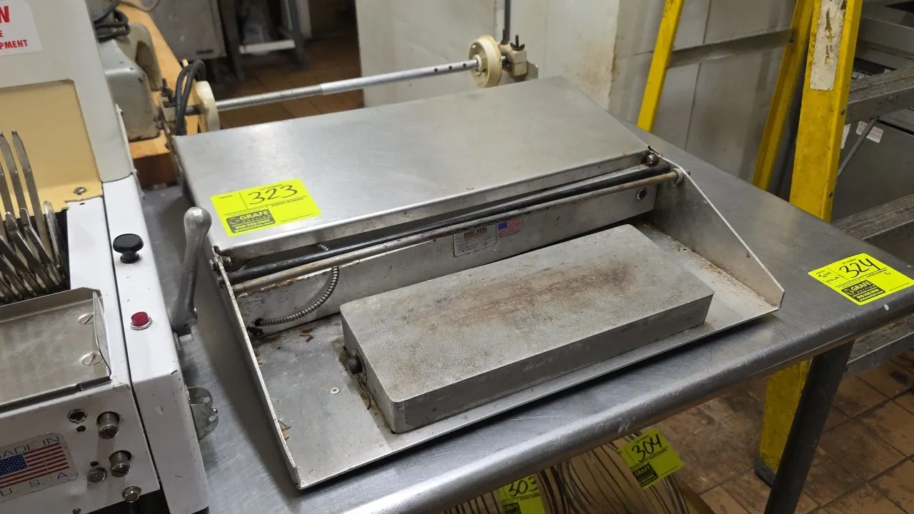 Heat Seal 625A stainless steel single roll film wrapper. Features a heated seal plate, cut-off rod, and rear film axle. 24"W. S/N: 2031875. Electrical