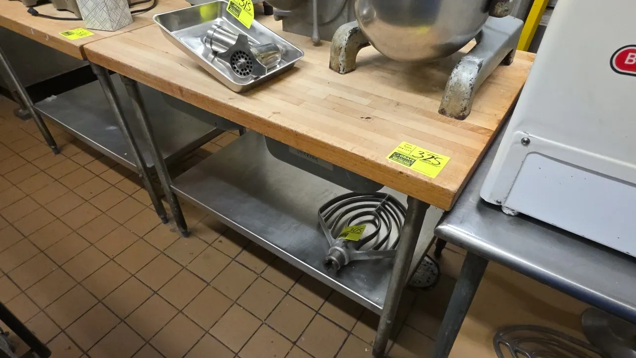 Butcher block work table. Features 2 under-mount drawers and a stainless steel undershelf. Includes contents of one drawer. 4'L. Mounted on tubular me