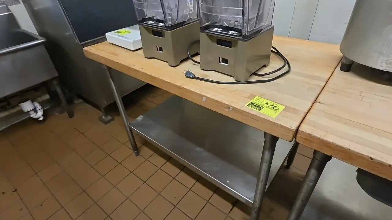 Butcher block top work table. Features a laminated wood butcher block top and stainless steel undershelf. 4'L. Mounted on tubular metal legs with adju