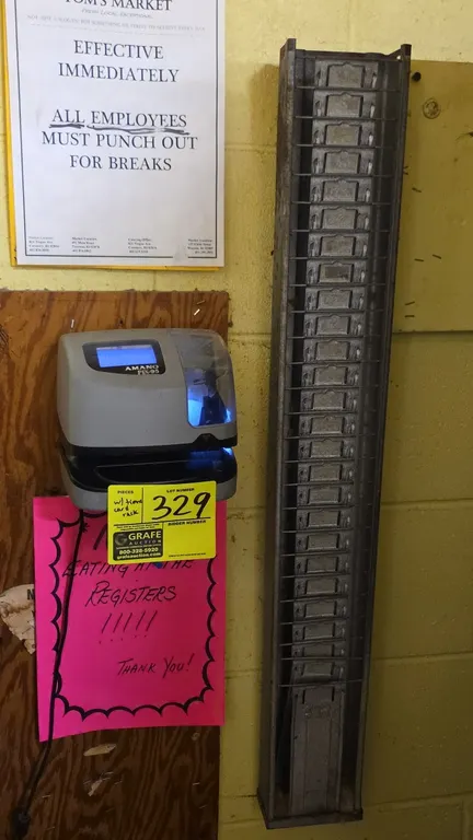 Amano PIX-95/A421 electronic time recorder with time card rack. Features digital display, illuminated print window, and wall-mount galvanized metal ti