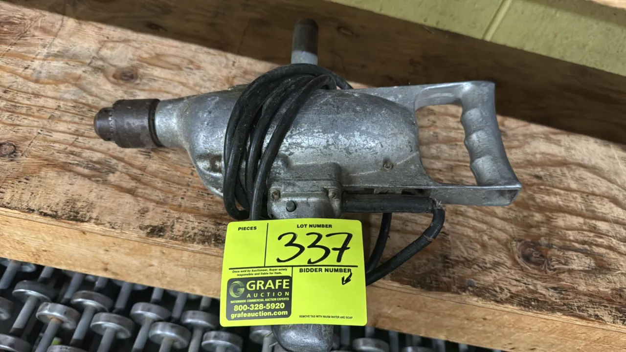 Electric hammer drill. Features cast aluminum housing, rear D-handle, pistol grip, auxiliary assist handle, and keyed drill chuck. Corded electric ope