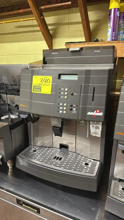 Schaerer Ambiente commercial espresso machine. Features dual bean hoppers for regular and decaf, digital display with push-button controls, integrated