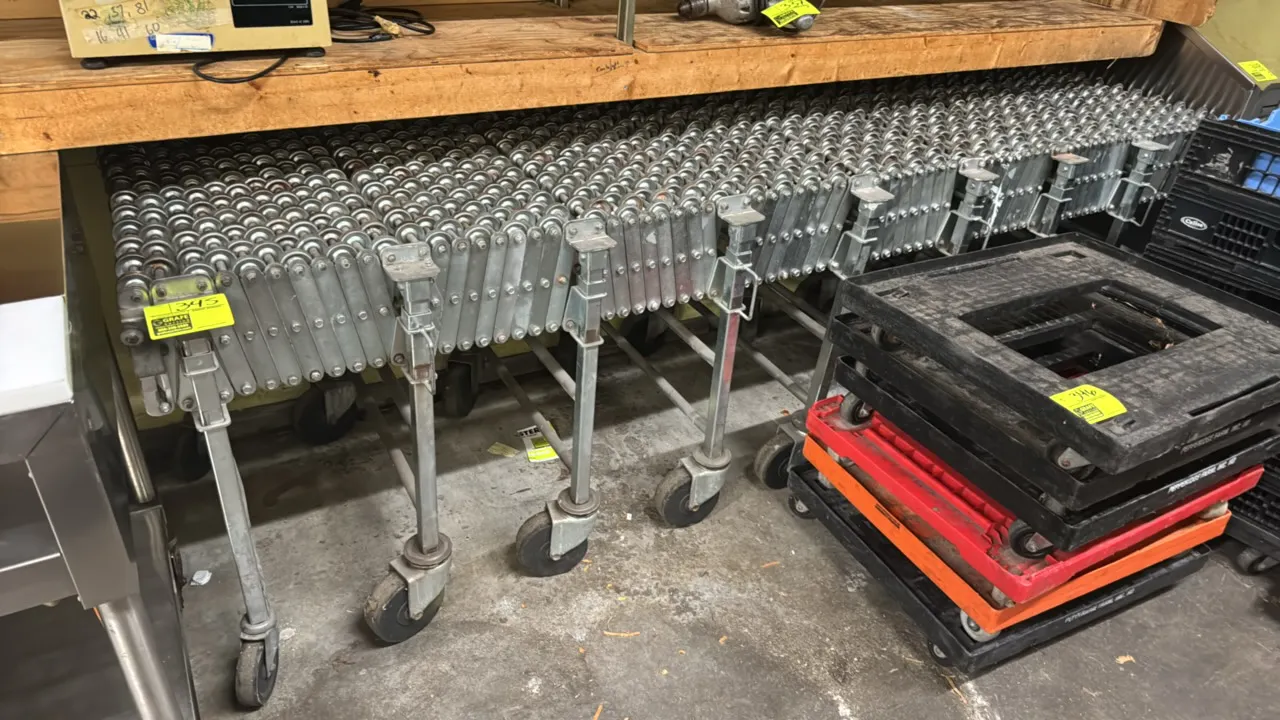 Flexible Material Handling NestaFlex 376 expandable skate wheel conveyor. Features steel skate wheels, scissor expansion mechanism, and adjustable-hei