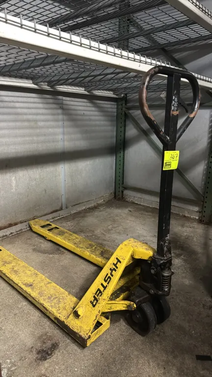 Hyster manual pallet jack. Features 3-position hand control, hydraulic lift mechanism, steel fork construction, and dual steer wheels.
