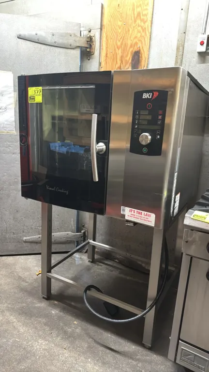 BKI C 1.06 electric combi oven. Features stainless steel construction, glass door, digital controls with rotary knob, and internal pan racks. S/N: 08