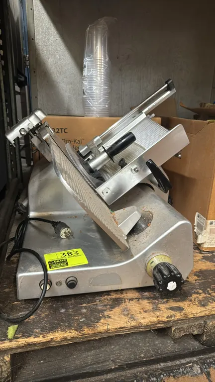 2008 Manconi 330 IK US commercial deli slicer. Features top-mounted sharpener assembly, product carriage with pusher, and slice thickness adjustment k