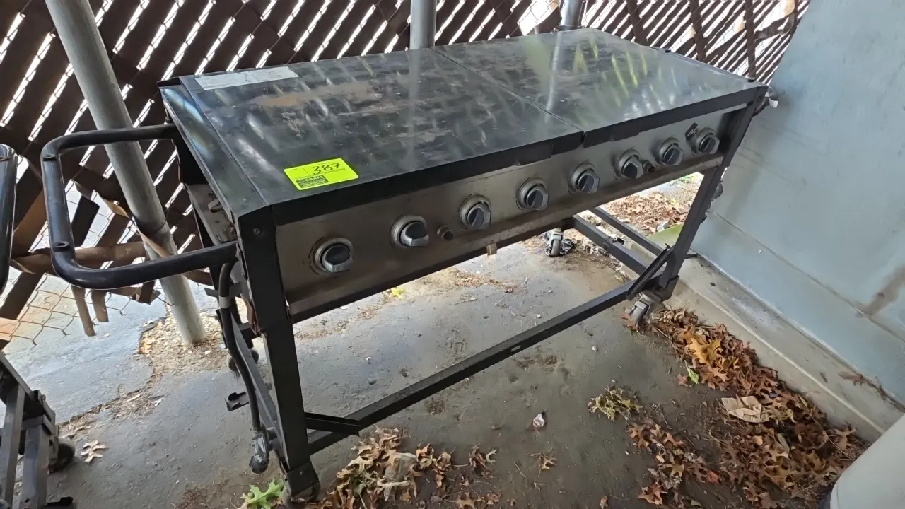 Member's Mark GR2039201-BC-00 portable 8-burner propane grill. Features stainless steel control panel, dual folding lid side shelves, wire cooking gra