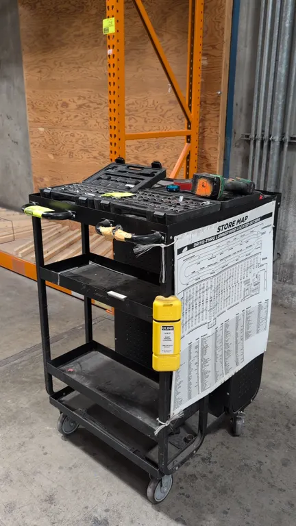 Rolling metal utility cart. Features a lipped top tray, dual push handles, open tiered shelving, and an enclosed 2-door perforated storage cabinet wit