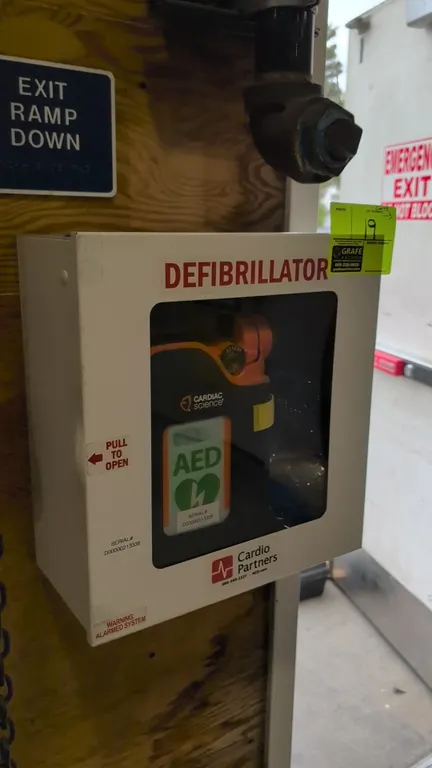 Cardiac Science automated external defibrillator (AED). Includes wall-mount metal storage cabinet with viewing window, fitted carrying case with shoul