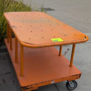 Two-tier metal platform cart. Features steel construction with orange finish and upper shelf with integrated tubular handles. Dimensions: 60"L x 30"W.