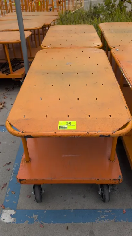 Metal 2-tier platform carts. Features orange finish, upper shelf, and lower platform deck. Mounted on 6 casters. Dimensions: 60"L x 30"W.