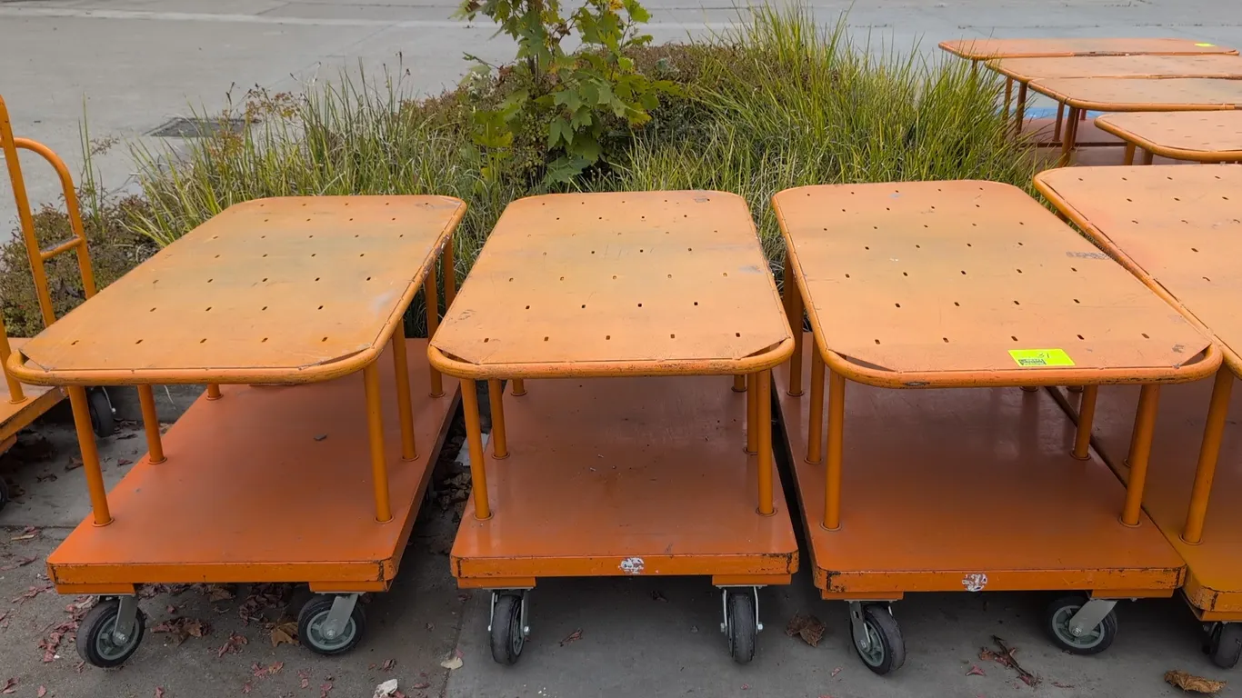 Metal 2-tier platform carts. Features upper and lower platform decks with tubular steel upright supports and an orange finish. 60" x 30". Mounted on c