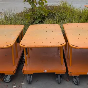 Metal 2-tier platform carts. Features upper and lower platform decks with tubular steel upright supports and an orange finish. 60" x 30". Mounted on c