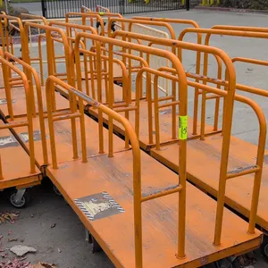 Metal platform lumber carts. Features tubular steel upright dividers and side rails with orange finish. 54" x 30". Mounted on casters.