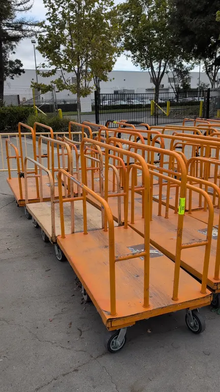 Metal platform lumber carts. Tubular steel divider rails with wood deck on steel frame. Dimensions: 54" x 30". Mounted on casters.