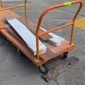 Metal platform cart with TrafficMaster laminate flooring planks. Features orange painted steel deck, tubular push handle, and a 6-wheel caster configu