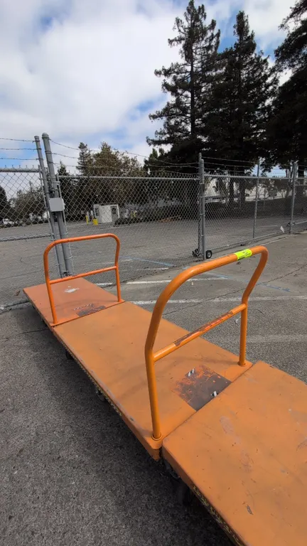 Metal platform carts. Features steel construction with orange finish, tubular push handle, and 6-wheel caster configuration. Dimensions: 54" x 30".