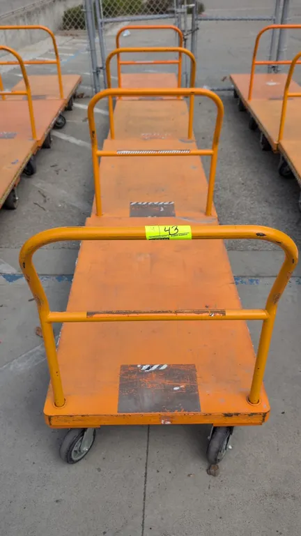 Metal platform carts. Features orange painted steel construction, removable tubular steel push handle, and a 6-wheel caster configuration with center-