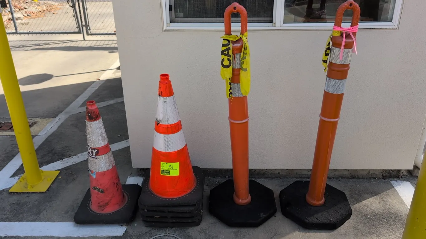 Assorted safety cones and delineator posts. Includes (6) traffic cones with square rubber bases and reflective collars, and (2) loop-top channelizer d