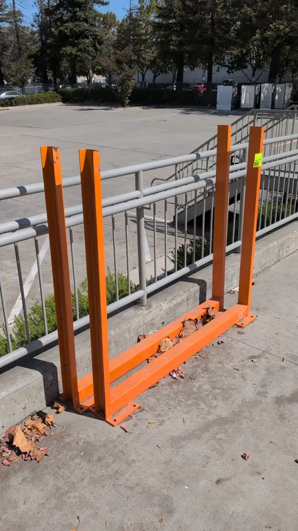 Metal storage stands. Features orange painted steel construction with dual vertical channel uprights and pre-drilled base mounting plates. 56" x 48"H.