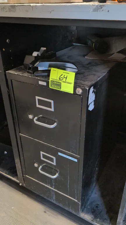 HON 2-drawer metal filing cabinet. Features black finish, drawer pull handles, and integrated label holders. 15"W x 29"H. Items on top and cabinet enc