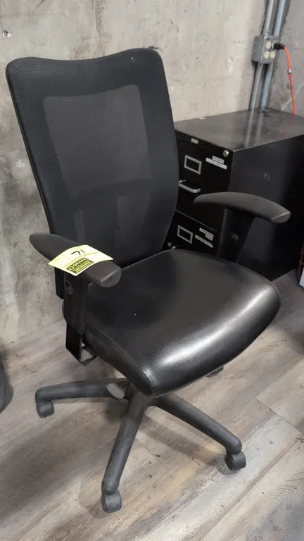 Faux leather cushioned office chair. Features a black mesh back, cushioned black faux leather seat, integrated armrests, and pneumatic seat height adj