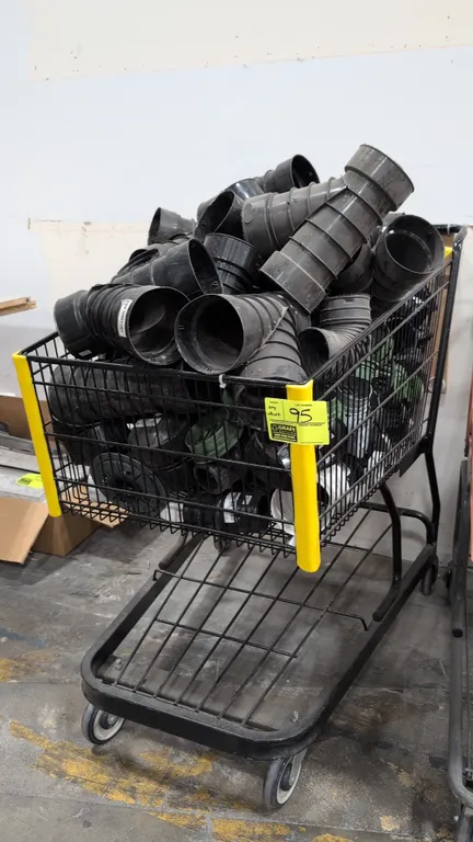 Assorted poly drainage fittings and 44" metal shopping cart. Includes corrugated wyes, elbows, tees, adapters, and round drain grates. Cart features a