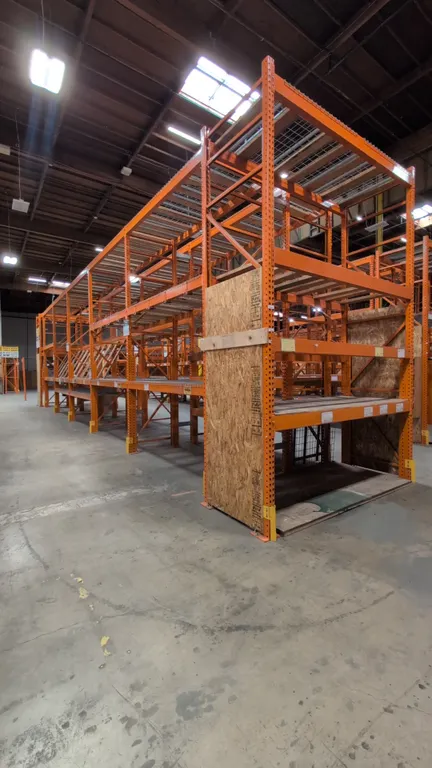 HMH metal teardrop pallet racking sections. Features 8'L sections, 5-1/2" crossbars, and wood and wire decking. Uprights measure 42"W x 168"H.