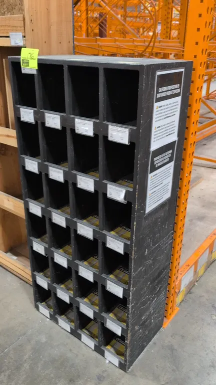 Wood cubby storage cabinet. Features 24 open compartments arranged in 4 columns and 6 rows, integrated shelf label holders, and a black painted finish