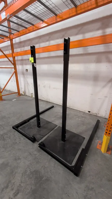 Metal adjustable stands. Features black steel construction, adjustable uprights with top mounting channels, and flat base plates with outrigger stabil