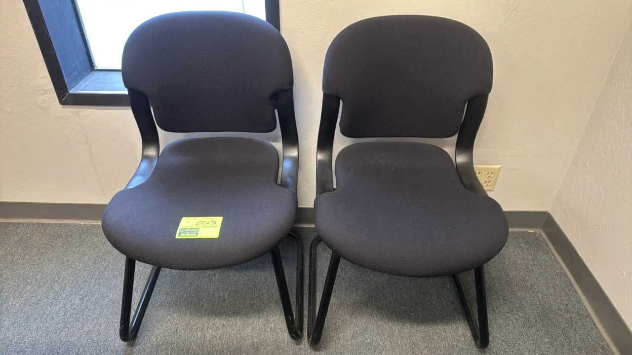 Upholstered metal frame guest chairs. Features padded black fabric contoured seat and backrest. Mounted on a black tubular metal sled base.