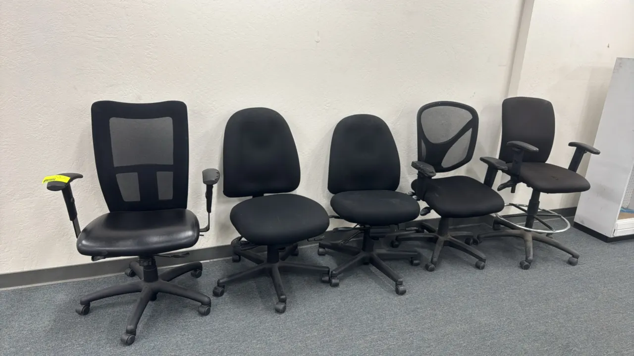 Assorted office chairs. Includes mesh-back task chairs, armless task chairs, and a drafting stool with foot ring. Features adjustable heights and 5-st