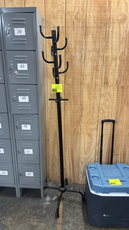 Metal coat and hat rack. Features black metal tubular construction with multi-tier hanging hooks and pegs. 6'H. Mounted on a 4-leg base. Lockers and c