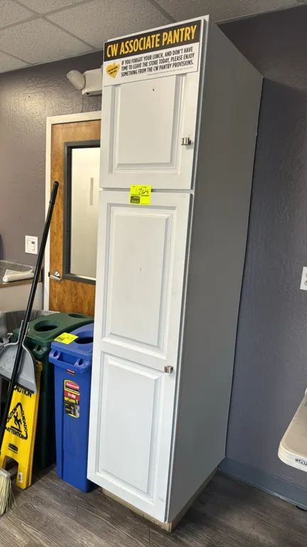 Tall laminate pantry cabinet. Features a 2-door configuration with white raised-panel doors, square metal pulls, and multi-tier interior shelving with
