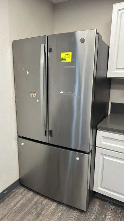 GE GNE27JYMNFFS stainless steel French door refrigerator with bottom freezer. Features adjustable glass shelving, door bins, internal water dispenser,