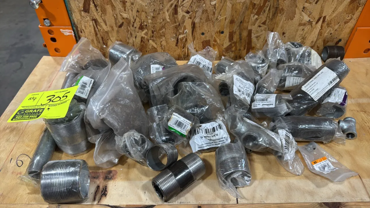 Assorted black steel pipe fittings. Includes various sizes of threaded pipe nipples, 90-degree and 45-degree elbows, reducing elbows, and tees. Mostly