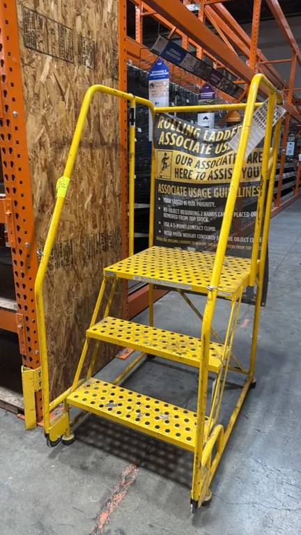 Cotterman 3-step rolling stock ladder. Features yellow steel construction, perforated slip-resistant treads, deep top platform, dual safety handrails,