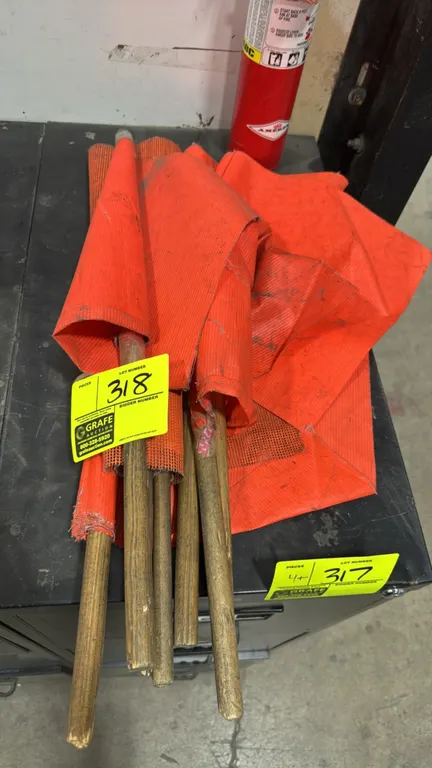 Orange safety flags with wooden handles. Features high-visibility orange material mounted on wood dowel staffs. Fire extinguisher and cabinet not incl