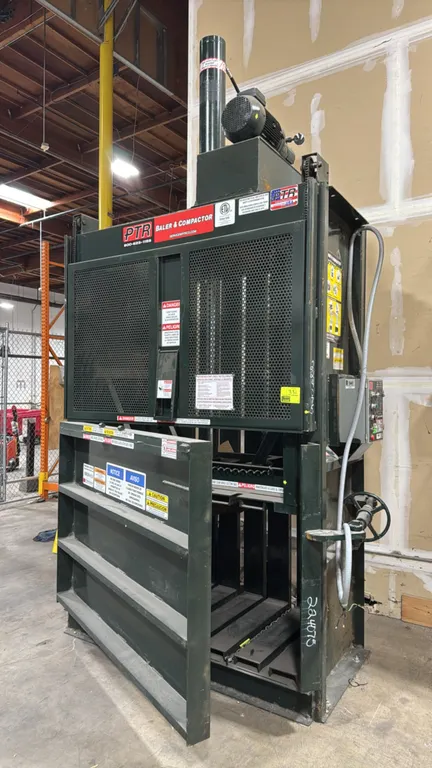 2022 PTR 2300HDX vertical baler. Features right-hand swing door with right-side screw lock wheel, wire bale ejector chains, and top-mounted hydraulic