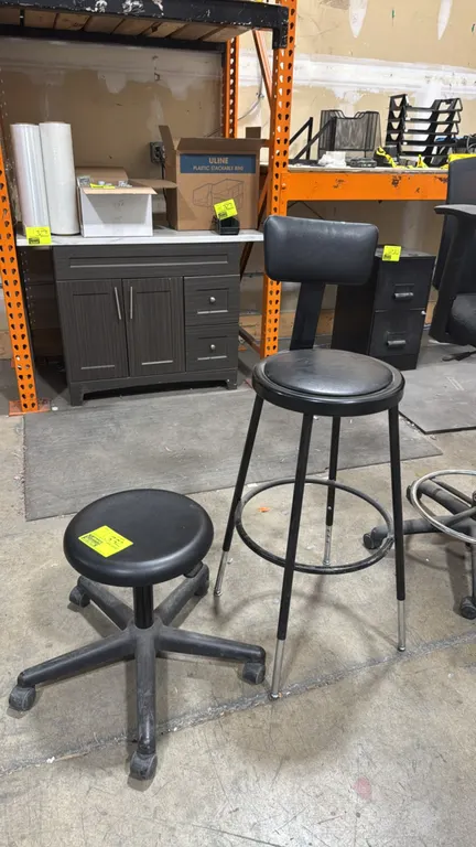 Seating lot. Includes (1) low rolling stool and (1) counter-height chair. Rolling stool features a round seat mounted on a 5-star base with casters. C