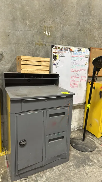 Metal receiving desk lot. Includes gray steel receiving desk, wooden slat crate, dry erase whiteboard, and wood-framed cork bulletin board. Desk featu