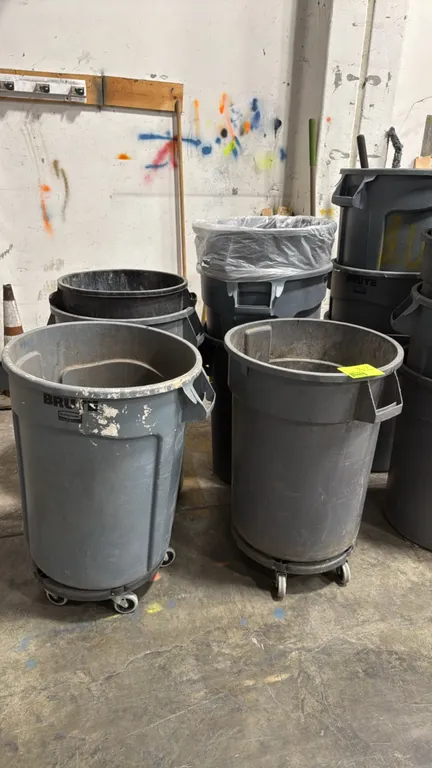 Rubbermaid Brute polyethylene trash cans. Features heavy-duty plastic construction with integrated side handles and reinforced rims. Includes rolling
